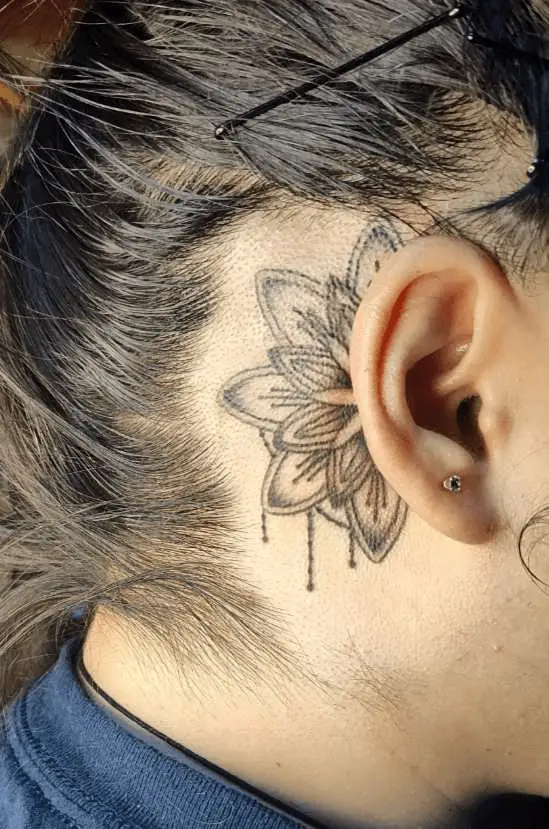 Custom floral tattoo by Brianna Lyons, featuring a flower gracefully behind a woman's ear