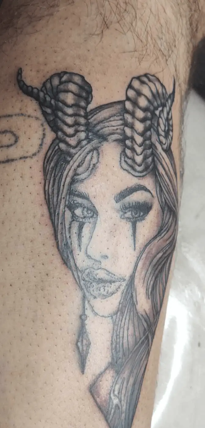 Artistic tattoo of a woman adorned with goat horns