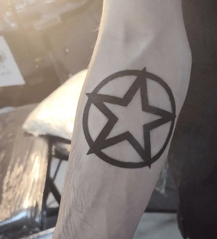 Simple geometric tattoo featuring a star and circle