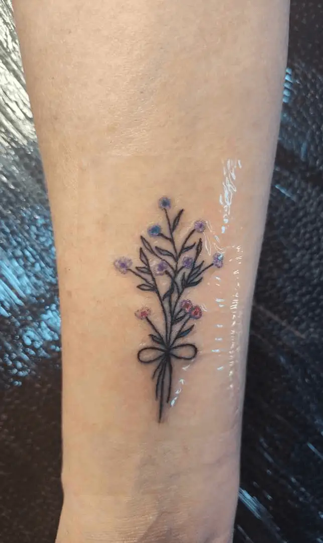 Artistic tattoo featuring a cluster of flowers resembling a bouquet